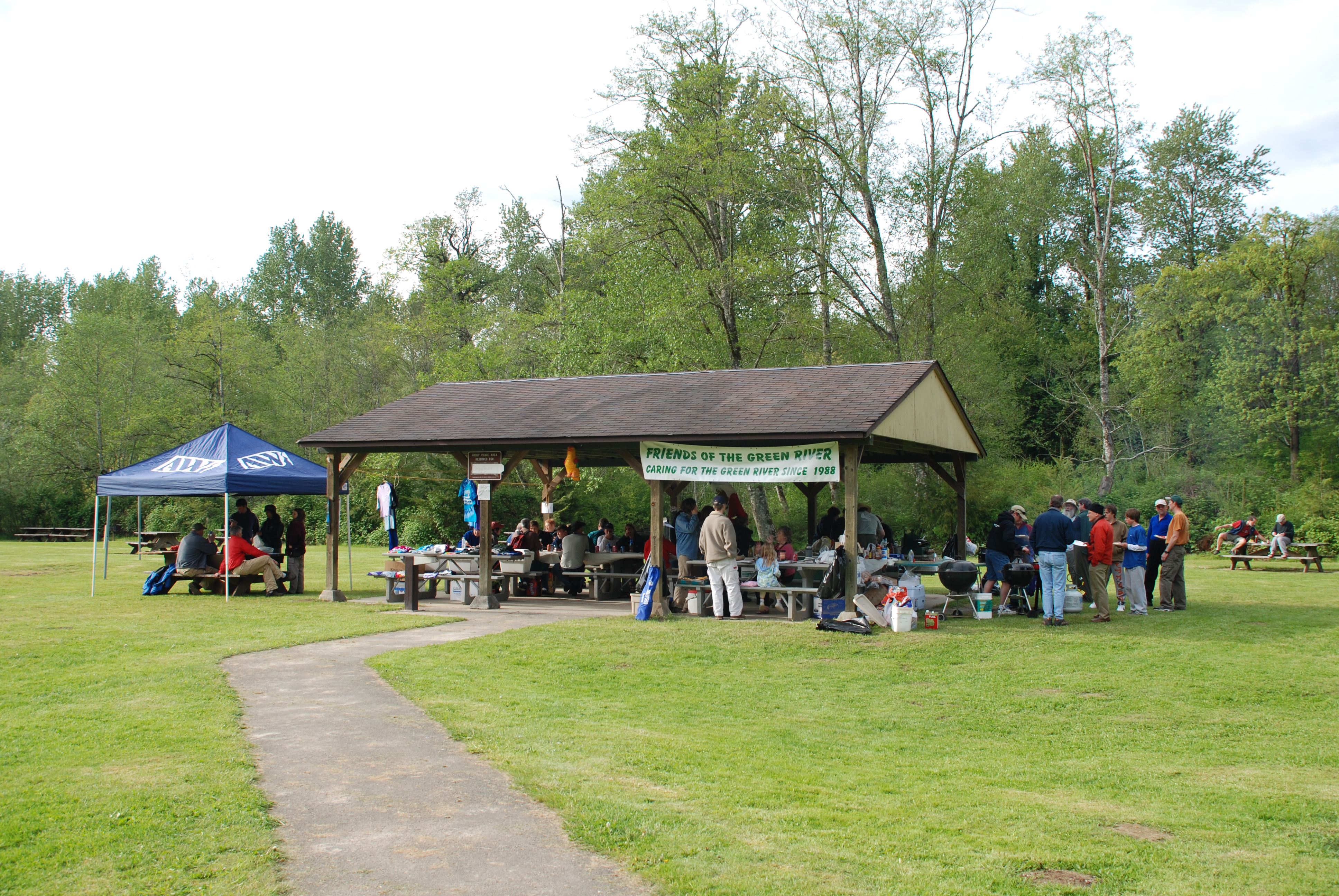 Volunteers gather for a picnic at Shelter #3 in Flaming Geyser State Park after the May 2007 Green River Clean Up, with lawn and riparian forest in the background.